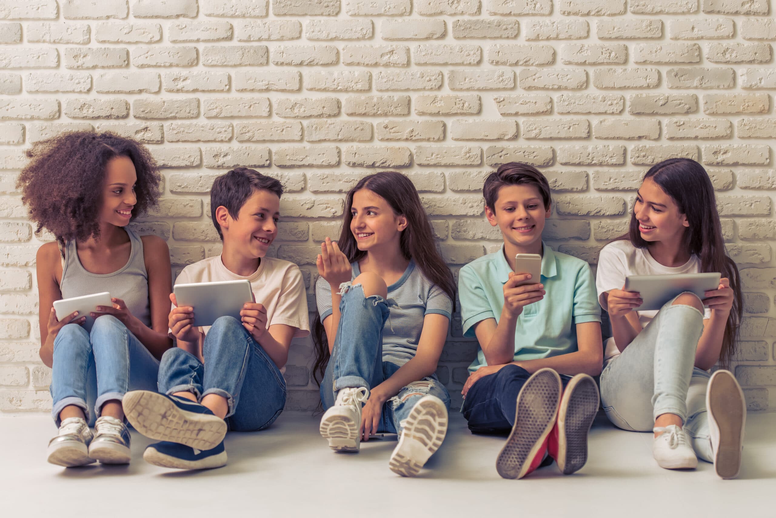 Group,Of,Teenage,Boys,And,Girls,Is,Using,Gadgets,,Talking